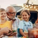 A grandfather laughing with his grandchildren